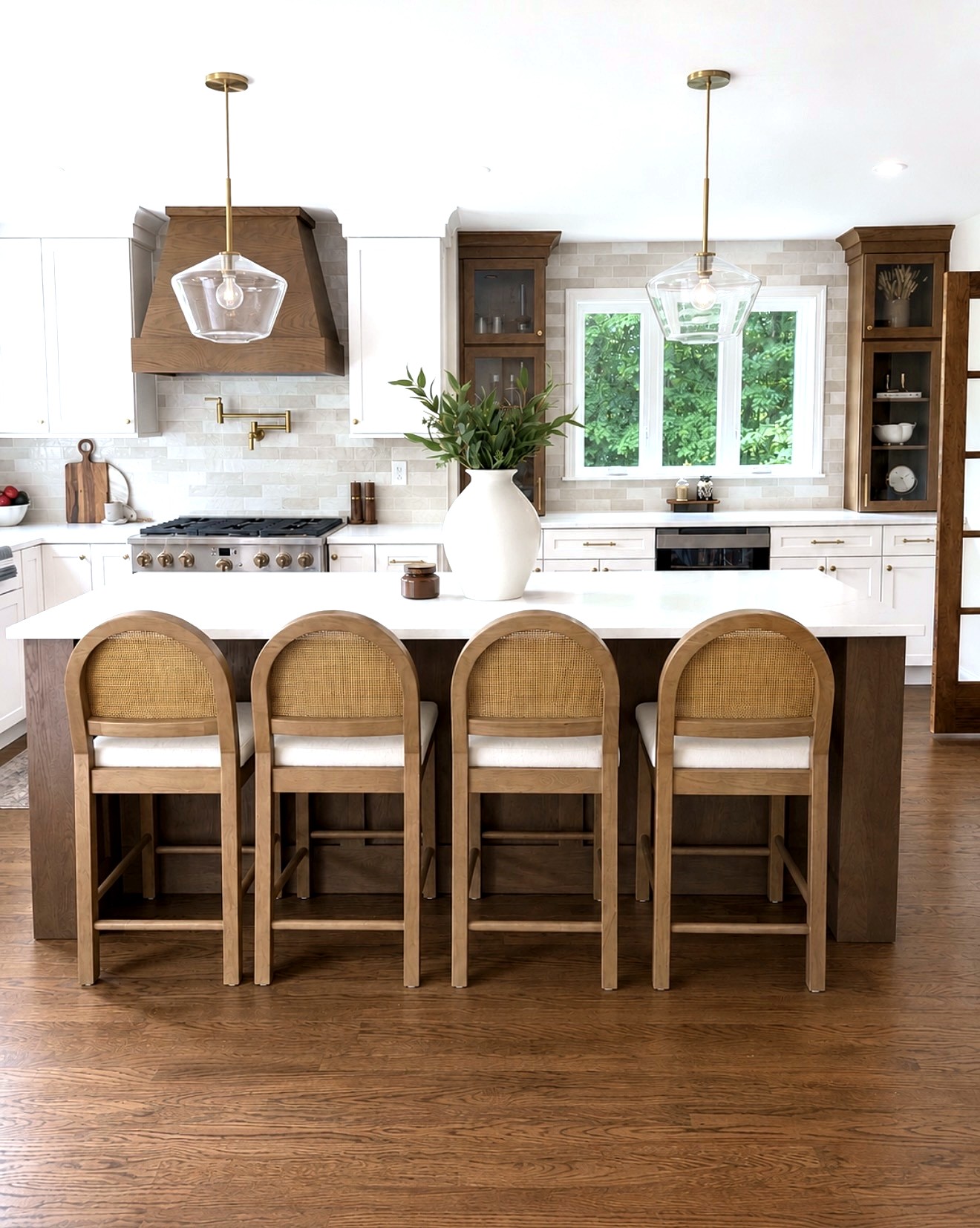 White oak and white shaker kitchen with quartz island, wood hood and brass pendants by Cabinets by Design in Southern NH