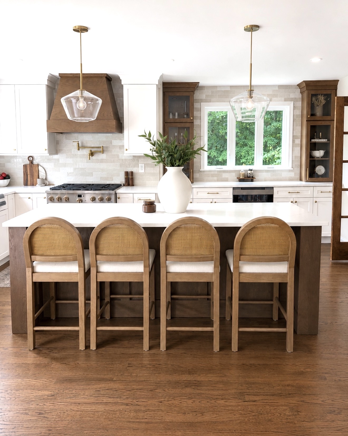 White oak and white shaker kitchen with quartz island, wood hood and brass pendants by Cabinets by Design in Southern NH